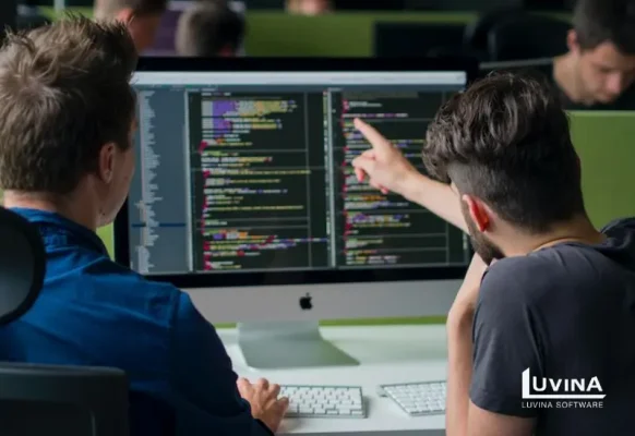 Software engineers collaborating on code structure in a modern office, visualizing the practical application of object-oriented software engineering principles.